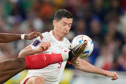 Aurelien Tchouameni, a la izquierda, lucha por la pelota con Robert Lewandowski.