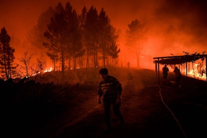 Las autoridades han tenido que evacuar parcialmente una aldea como precaución, según ha indicado Protección Civil, que ha informado de que siete bomberos han resultado heridos y una persona ha tenido que ser trasladada en helicóptero a un hospital de Lisboa con quemaduras de primer y segundo grado. En la imagen, vecinos en el incendio forestal en la zona de Amendoa.