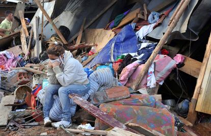 Una mujer permanece sentada sobre los escombros de una casa derruida por las fuertes lluvias en el barrio de La Gabriela, en Medellín, Colombia.