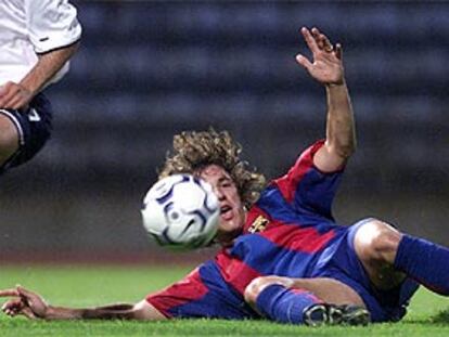 Puyol despeja la pelota durante un partido con el Barça.