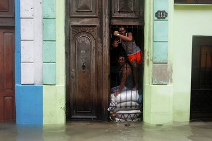 En la imagen, dos personas posan a la entrada de su casa de La Habana (Cuba) subidos encima de sacos de arenas.