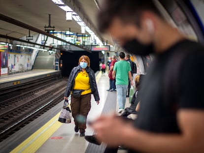 Usuarios del metro de Madrid usan mascarillas, que siguen siendo obligatorias en el transporte público.