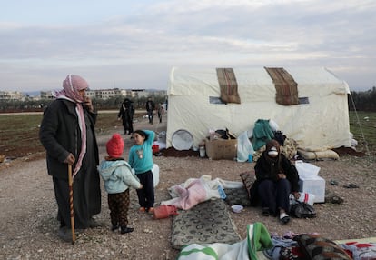 Earthquake survivor Mahmoud Abd el-Shehiel stands with his children and injured sister outside tents erected for people affected by a devastating earthquake, in rebel-held town of Jandaris, Syria.