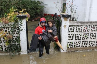 Un bombero rescata a una vecina de Txomin Enea durante las inundaciones del año pasado.