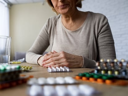 Una mujer mirando  pastillas.