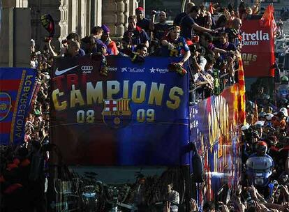 Los jugadores saludan a los aficionados desde el autobús que recorre las calles de Barcelona.