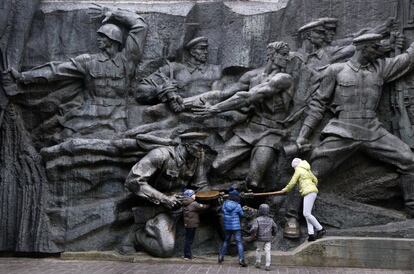 Unos niños juegan en el monumento del Soldado Desconocido, un monumento a los veteranos de la Segunda Guerra Mundial, en un parque en Kiev, Ucrania.