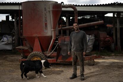 Josep Ball-Llosera junto a su perro, detrás el molino donde prepara el pienso en Santa Coloma de Farners, Girona.