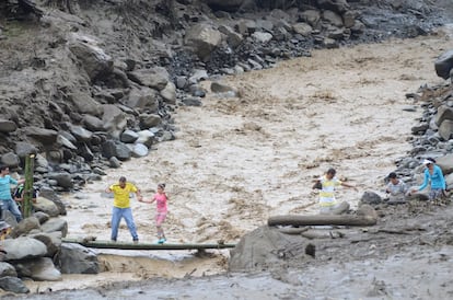 Residentes cruzan un barranco desbordado en Salgar (Colombia). Un total de 377 personas entre socorristas, bomberos, soldados, policas y otros reanudaron la bsqueda de desaparecidos tras la avalancha registrada en el pueblo de Salgar, en el noroeste de Colombia, donde han muerto al menos 62 personas y un nmero indeterminado siguen desaparecidas.