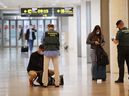 Agentes de la Guardia Civil realizan un control a viajeros procedentes de Ámsterdam a su llegada al aeropuerto de El Prat, este martes.