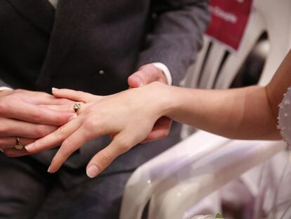 Un hombre coloca el anillo a su mujer durante una ceremonia en noviembre de 2022.