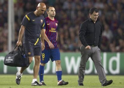 Iniesta se retira lesionado durante el partido contra el Milan.