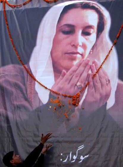 Un seguidor de Bhutto lanza flores sobre un retrato de la ex primera ministra en Peshawar.