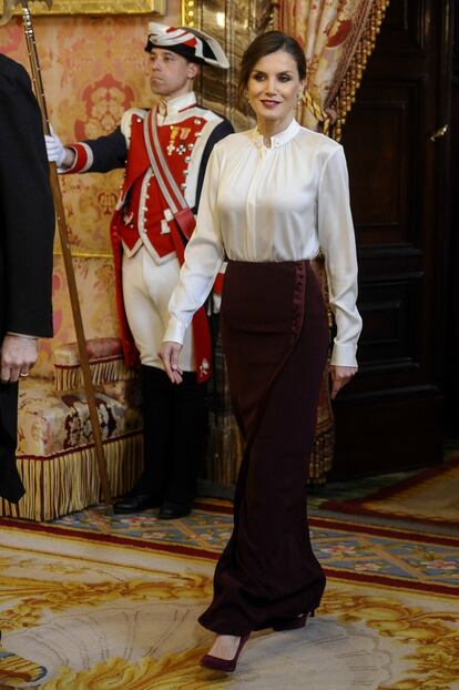 La reina Letizia, en una recepción con el cuerpo diplomático en Madrid, el pasado enero, con una falda en color borgoña que combinó con una blusa blanca de cuello 'mao' de Hugo Boss y unos tacones de Uterqüe.