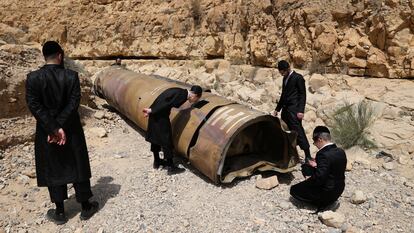 Un grupo de judíos ultraortodoxos observa los restos de un misil iraní descubierto cerca de la ciudad de Arad, este domingo.