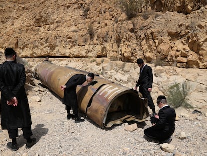 Un grupo de judíos ultraortodoxos observa los restos de un misil iraní descubierto cerca de la ciudad de Arad, este domingo.