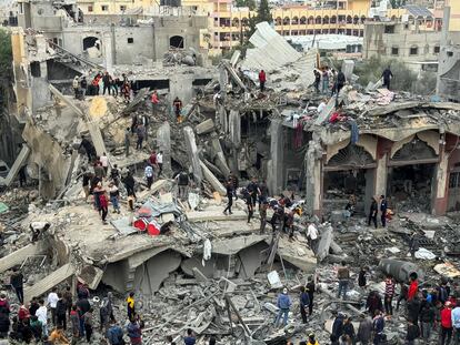 Decenas de personas buscan supervivientes entre los escombros de un edificio colapsado atacado por Israel este miércoles en Rafah. 