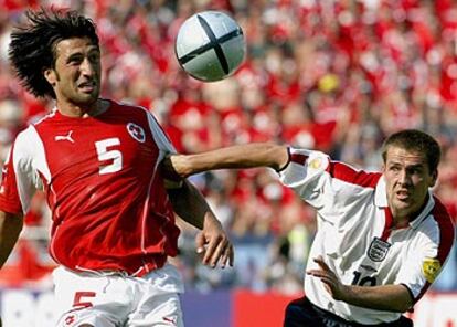 Owen agarra del brazo a Murat Yakin en su carrera hacia el balón.