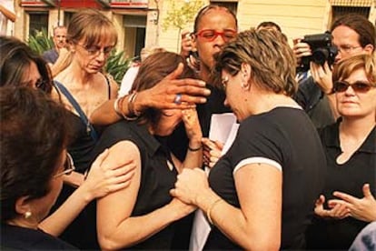Una de las mujeres que perdió a su marido en el accidente de Turquía es consolada durante el homenaje.