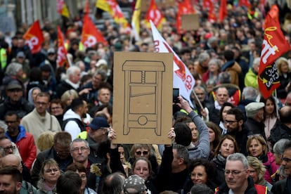 Un manifestante exhibe un cartel con una guillotina en la manifestación de Laval, en el oeste de Francia, el 23 de marzo.