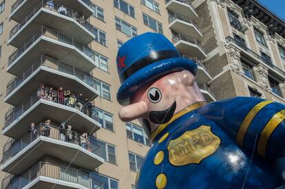 Un grupo de gente observa desde sus viviendas un globo gigante de 'Harold, el oficial de policía' en Central Park West.