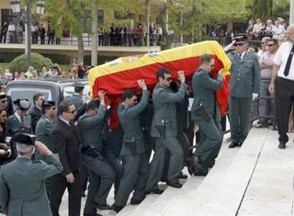 El féretro con los restos mortales del guardia civil Juan Manuel Piñuel Villalón es trasladado a hombros por sus compañeros al interior de la capilla del cementerio de Málaga.