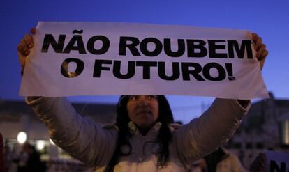 Una manifestante con una pancarta donde se lee &quot;No rob&eacute;is el futuro&quot;, en una protesta contra los recortes en Lisboa, en diciembre.