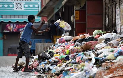 Un hombre lanza basura en una calle en Colombo, Sri Lanka. Cientos de toneladas de desperdicios podridos se acumularon en la capital del país este martes después de que el vertedero principal se cerrara tras un accidente que mató, al menos, a 30 personas.