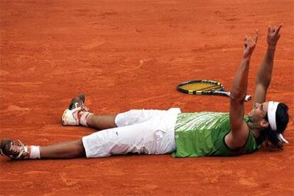 Nadal señala al cielo desde el suelo tras conseguir el último punto y conquistar el torneo.