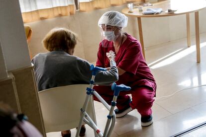 Una empleada conversa con una mujer mayor en la residencia de ancianos Santa María de Montecarmelo, en Madrid.