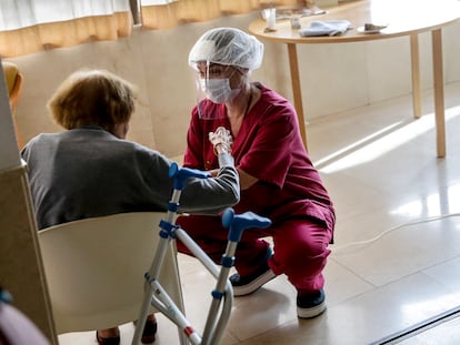 Una empleada conversa con una mujer mayor en la residencia de ancianos Santa María de Montecarmelo, en Madrid.