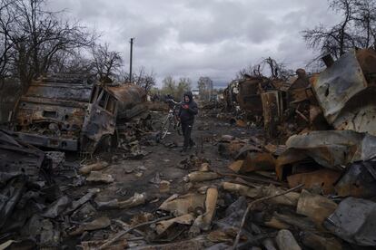 Un hombre lleva una bicicleta por una calle llena de vehículos militares rusos destruidos cerca de Chernihiv, en el norte de Ucrania, el domingo.