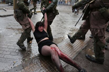 La policía detiene este lunes a una manifestante durante una nueva jornada de protestas a nivel nacional en contra del Gobierno, en la Plaza Italia de Santiago (Chile).