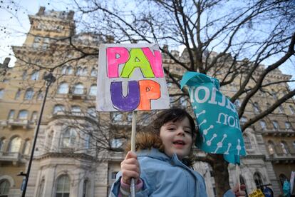 Un niño sostiene un cartel durante una marcha de trabajadores en huelga cerca de Downing Street, en Londres.