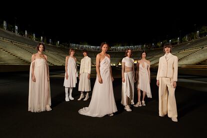 A pocas semanas de que comiencen los Juegos Olímpicos de Tokio, Dior ha viajado al corazón olímpico, al estadio Panatenaico de Atenas, para presentar su colección Crucero 2022, la noche del jueves. Se trataba del primer gran desfile desde que comenzó la pandemia, el primero en mucho tiempo con público, y se ha convertido en toda una llamada al optimismo como ya hiciera el propio Christian Dior en 1947, tras la Segunda Guerra Mundial. Si el couturier ofreció al mundo el New Look, una fantasía de excesos tras las restricciones de la contienda, Maria Grazia Chiuri, la actual directora creativa de la casa, ha apostado por una comodidad que no renuncia al dramatismo.
 
Precisamente una sesión de fotos en el Partenón en 1951, con aquella silueta que marcó una década, es la chispa que dispara esta nueva colección en tono contemporáneo, que juega con el legado griego sin caer en la nostalgia. Alusiones al mundo del deporte conjugadas con lo helénico. ¿Su inspiración? La vida y el trabajo de Alexandre Iolas, un bailarín que se convirtió en coleccionista de arte y al que la italiana descubrió en una exposición de Francesco Vezzoli en Milán el año pasado, La Casa Iolas. 
 
Entre los artistas que Iolas coleccionó estaba el pintor Giorgio de Chirico, nacido en Grecia y con fuertes vínculos con Italia. La obra del pionero surrealista se convirtió en referencia para Chiuri y ha impregnado la monumental puesta en escena en el estadio donde nacieron los Juegos Olímpicos modernos en 1896. Mientras las modelos recorrían la pista de atletismo sonaba la orquesta sinfónica de Atenas y la voz de la artista Ioanna Gika, creando una atmósfera que recogía también el espíritu de las fotografías de Herbert List en Grecia en los años treinta.
 
En la cuna de la civilización no han faltado las referencias a mitos universales, en especial a Antígona. La túnica griega, el péplum, fue objeto de una exposición en el Met en 2003 titulada Goddess, y ha estado presente en el trabajo de Chiuri desde su llegada a la maison; aquí se fusiona con elementos en clave deportiva. Los plisados y drapeados se llevan sobre camisetas técnicas, con capuchas y, por supuesto, deportivas. Entre Atenea y la futbolista Megan Rapinoe. Tampoco han faltado clásicos de la casa como la chaqueta Bar y favoritos de la diseñadora como las joyas corporales o los grafismos.
 
En este punto actual de la pandemia el mundo quiere volver a vestirse y disfrutar, pero sin renunciar a la funcionalidad. ¿El final? Tras una docena de vestidos de diosa y una novia inspirada en la Odette de El lago de los Cisnes (que ha provocado comparaciones con Bjork en 2001 en los Oscar), varios minutos de fuegos artificiales. Se trataba de recuperar la ilusión, la ocasión lo merecía.