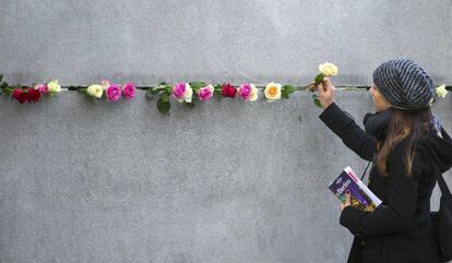 Una turista deixa una flor per commemorar la caiguda del mur de 45 quilòmetres que va mantenir dividida Alemanya durant dècades.