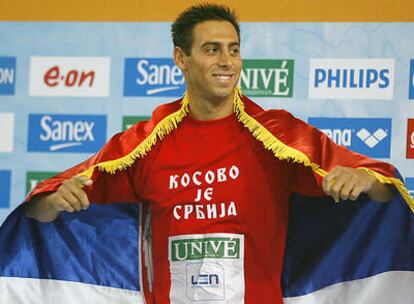 Milorad Cavic posa con la bandera serbia y una camiseta en la que se lee "Kosovo es Serbia".