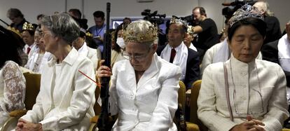 A woman wears a crown and holds an unloaded weapon as she bows her head during services at the World Peace and Unification Sanctuary, Wednesday Feb. 28, 2018, in Newfoundland, Pa. Worshippers clutching AR-15 rifles participated in a commitment ceremony at the Pennsylvania-based church.The event Wednesday morning led a nearby school to cancel classes for the day.The church's leader, the Rev. Sean Moon, said in a prayer that God gave people the right to bear arms. (AP Photo/Jacqueline Larma)