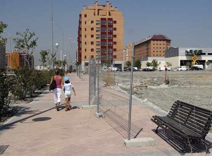 Dos vecinos del nuevo barrio del ensanche de Vallecas, junto a solares y edificios en obras.