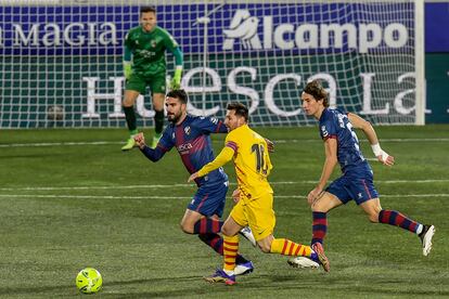 Messi conduce ante la presión de los jugadores del Huesca.