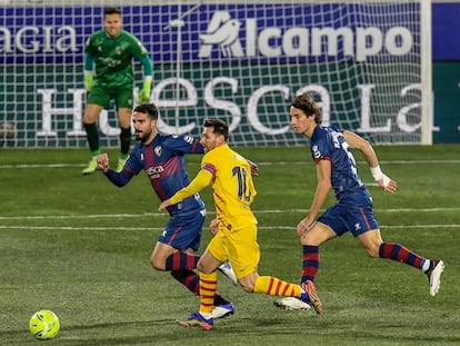 Messi conduce ante la presión de los jugadores del Huesca.