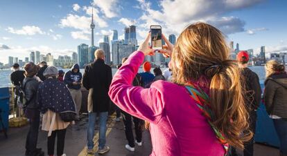 Turistas a bordo de un ferri frente al puerto de Toronto (Canadá).