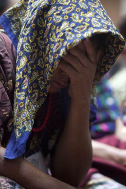 Una mujer indígena se cubre el rostro mientras escucha los testimonios.