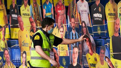 Un operario coloca fotos de aficionados en la grada del Estadio de La Cerámica el pasado mes de junio.