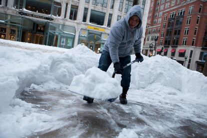 Algunos trabajadores se afanan en quitar la nieve de las calles principales tras la llegada de Juno. 