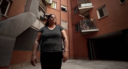 Sira Olivares, una mujer cuya hipoteca ha sido vendida a un fondo buitre, frente a su casa en un barrio de Madrid.