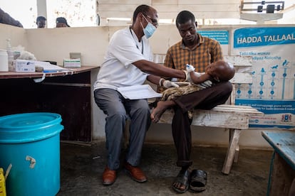 Muridi Haji, de casi dos años y medio, está en brazos de su padre Abdelkader haji, de 27 años, mientras lo examina un médico en el centro de estabilización de Kismayo. En el área de recepción se decide, tras un breve chequeo, el tratamiento que recibirán los niños.