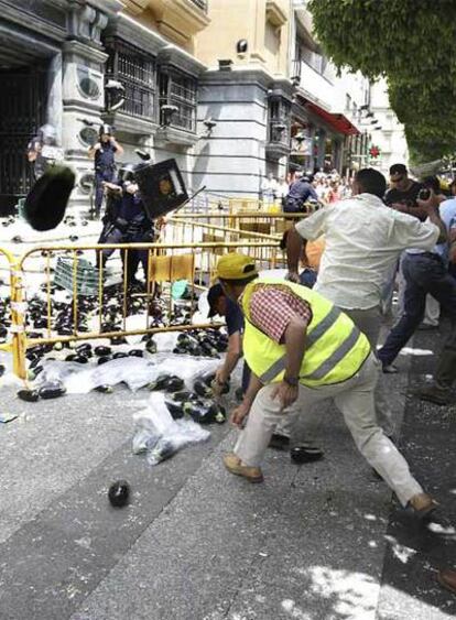 Varios agricultores lanzan berenjenas a la policía durante su protesta ante la Delegación de Hacienda.