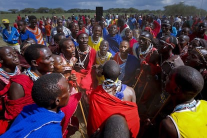 Un grupo de jóvenes hombres masai cantan y bailan en círculo para celebrar la victoria de su manyatta (pueblo) durante los Juegos Olímpicos de Maasai 2014, celebrado en la aldea Kimana cerca de la frontera con Tanzania, junto al Parque Nacional de Amboseli, en Kenia, el 13 de diciembre de 2014. Los cientos de jóvenes hombres masai que representan cuatro manyattas (pueblos) compitieron en seis partidos para ganar medallas, premios en efectivo o un toro de cría.