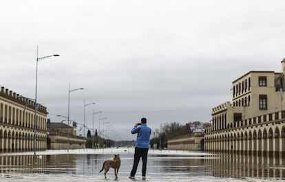 Un hombre toma una fotografía junto a una calle inundada en la localidad de Luján este miércoles.